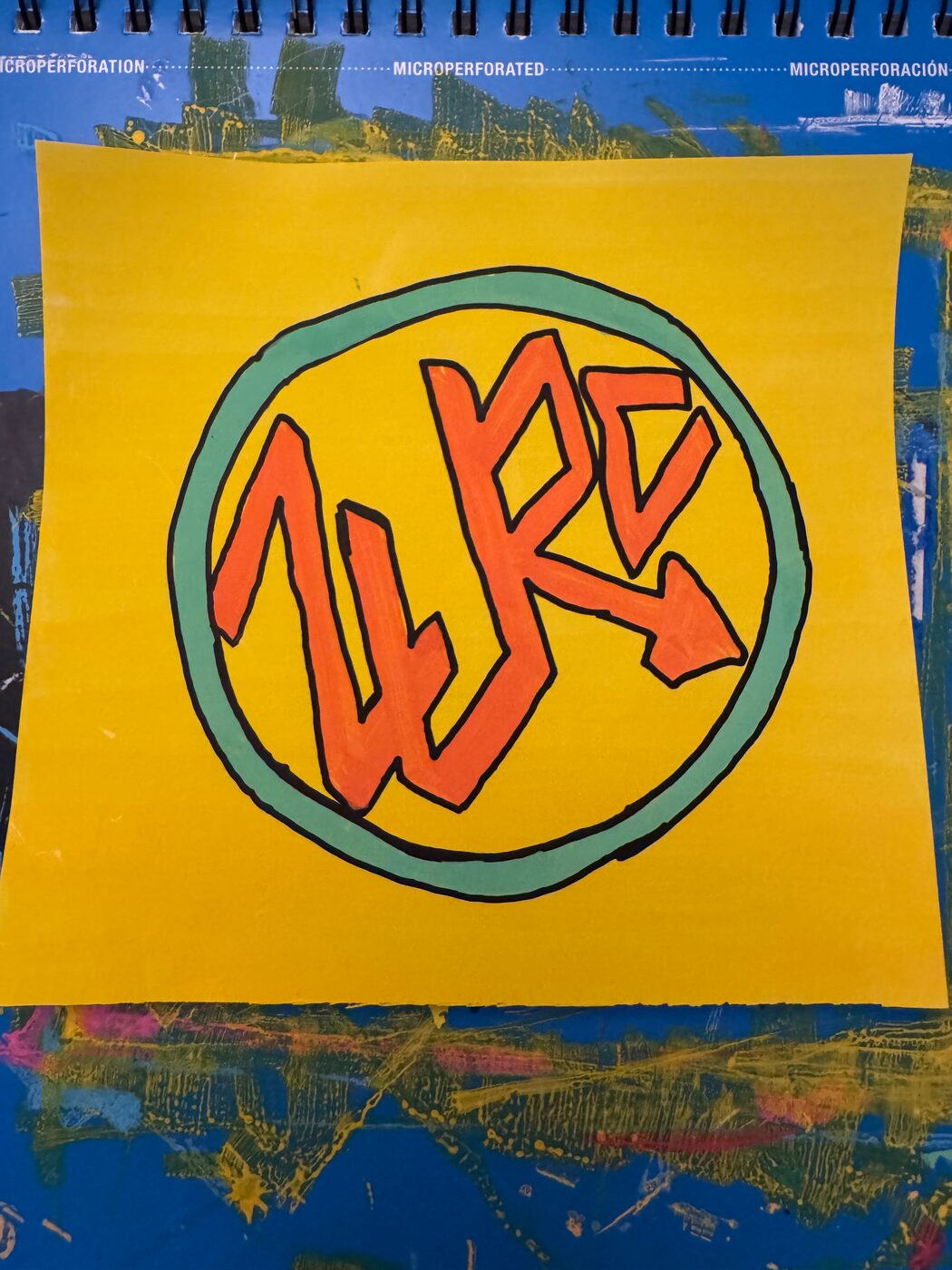 ZURC in orange letters outlined in black inside a teal ring, on a yellow sheet